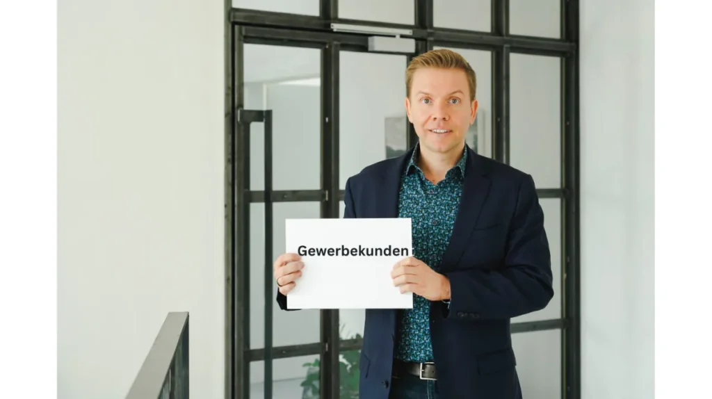 Matthias Reindl hält ein Schild mit der Aufschrift „Gewerbekunden“