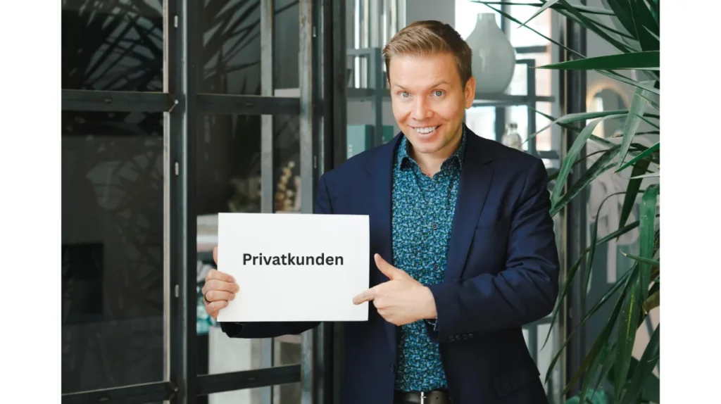 Matthias Reindl hält ein Schild mit der Aufschrift „Privatkunden“