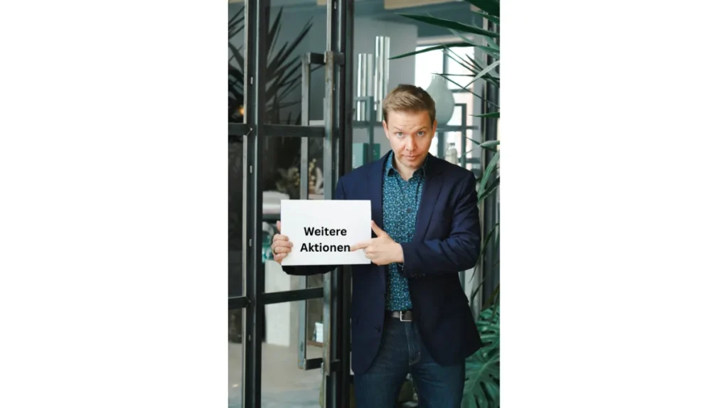 Matthias Reindl hält ein Schild mit der Aufschrift „Weitere Aktionen“
