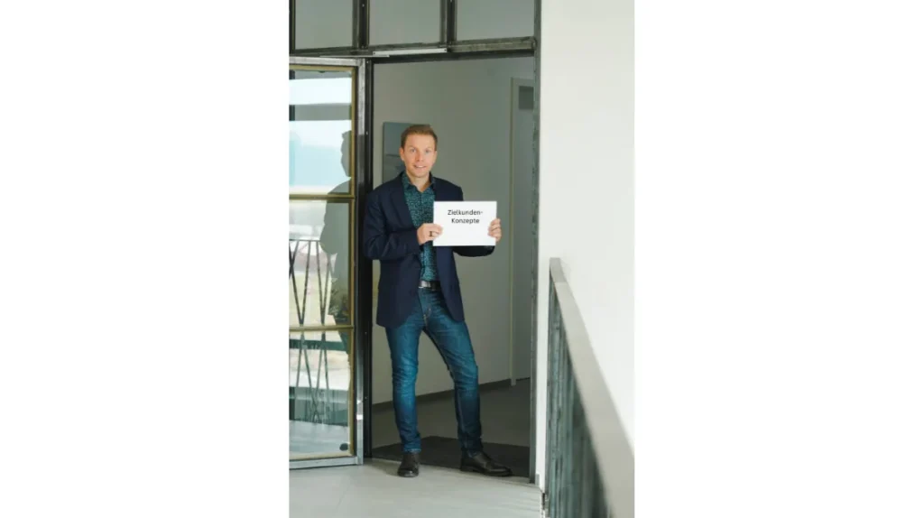 Matthias Reindl hält ein Schild mit der Aufschrift „Zielkundenkonzepte“