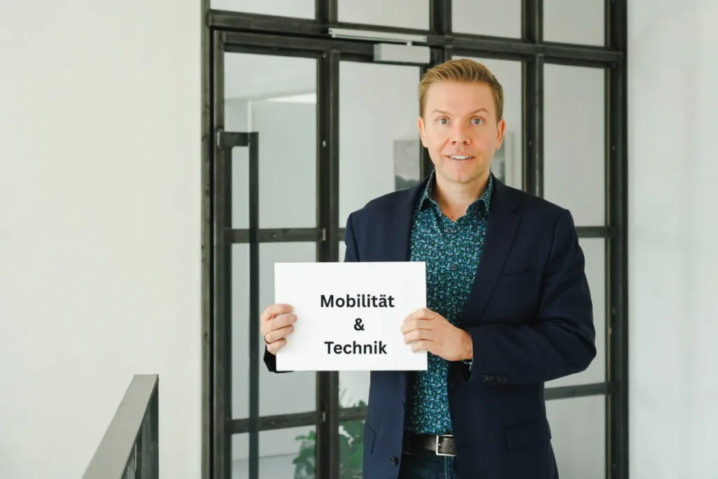 Matthias Reindl hält ein Schild mit der Aufschrift „Mobilität & Technik“