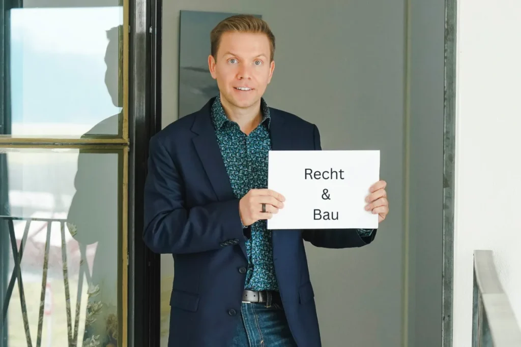 Matthias Reindl hält ein Schild mit der Aufschrift „Recht & Bau“